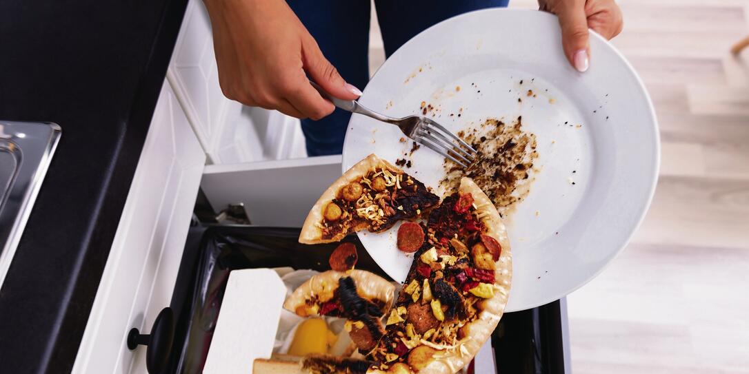 Person Throwing Pepperoni Pizza In Dustbin