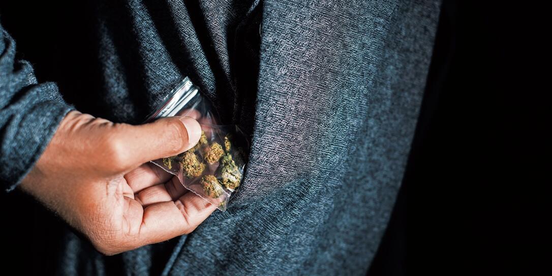 young man with a bag of marihuana buds