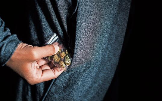 young man with a bag of marihuana buds