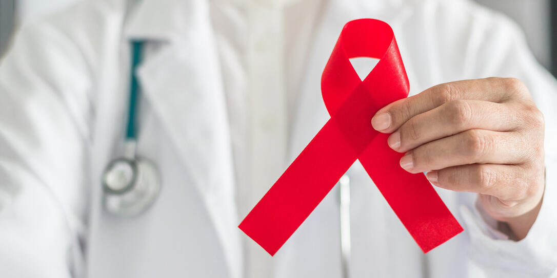 Aids red ribbon in doctor's hand for World aids day and HIV virus awareness concept