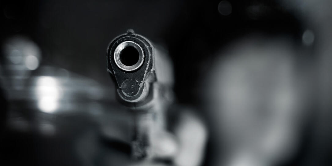 Black and white, woman pointing old gun to front