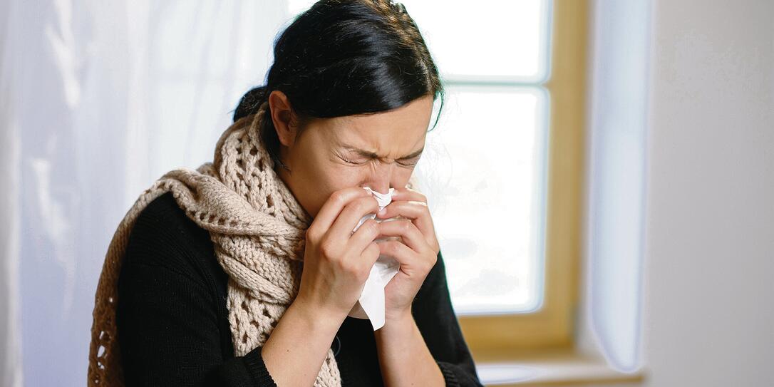 YOUNG WOMAN BLOWING HER NOSE