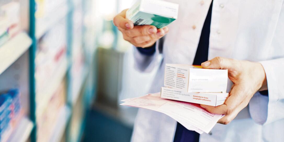 Pharmacist's hands taking medicines from shelf