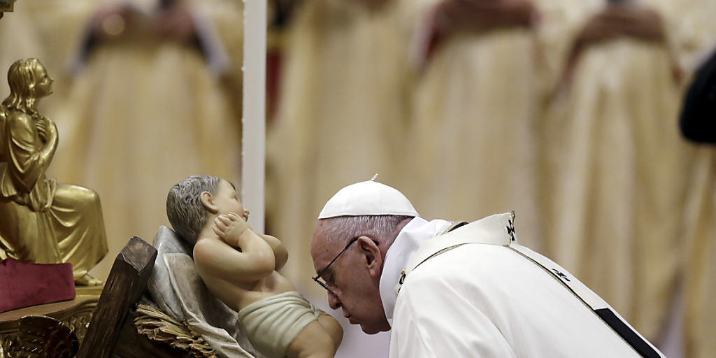 Christmesse im Petersdom: Papst Franziskus küsst bei eine Statue des Jesuskinds.