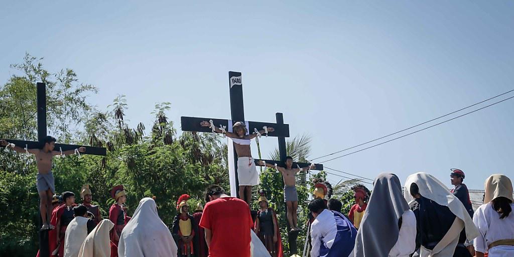 Im philippinischen Dorf San Juan stellen Gläubige die am Karfreiteag die Kreuzigung Jesu Christi nach - drei Männer liessen sich dabei an Kreuze nageln. Im philippinischen Dorf San Juan stellen Gläubige die am Karfreiteag die Kreuzigung Jesu Christi nach - drei Männer liessen sich dabei an Kreuze nageln.
