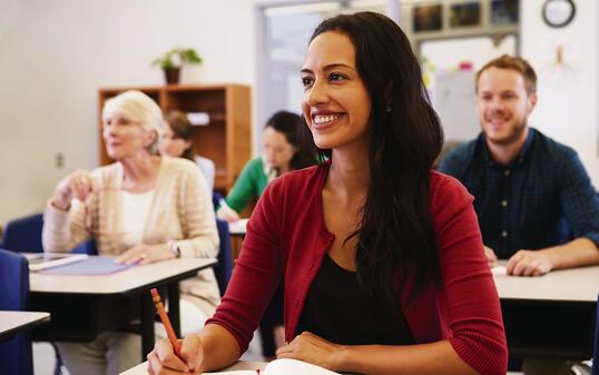 Hispanic woman studying at adult education class looking up