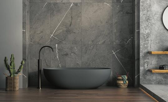 A modern bathroom featuring an anthracite bathtub, marble ceramic tiles on the back wall, parquet flooring, plants and a basket. 3d rendering