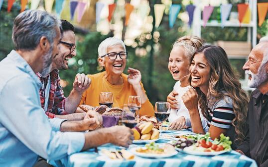 Happy family eating and drinking in the back yard