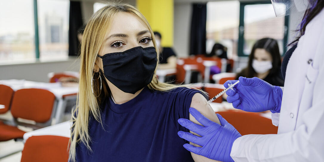 Nurse gives students a vaccination in school during coronavirus pandemic