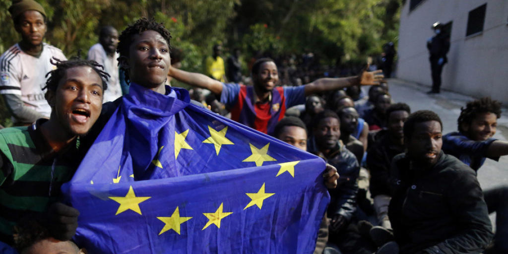 Einer der Flüchtlinge, die am Freitag erfolgreich den Grenzzaun bei Ceuta gestürmt hatten, hält eine EU-Flagge in seinen Händen. Am Montag gelang es erneut Hunderten Flüchtlingen, die spanische Exklave in Marokko zu erreichen. (Archiv)