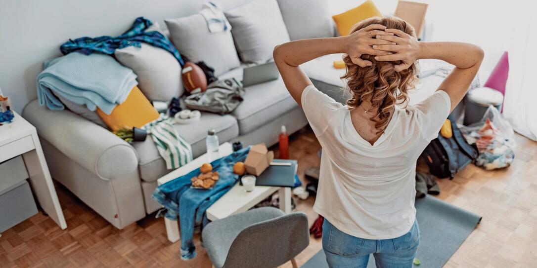 Housewife at modern home on sunny day looking at dirty room.