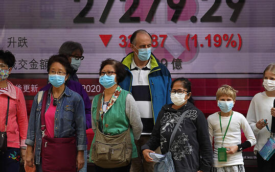 Die Furcht vor dem Coronavirus kommt nun immer stärker an den Börsen an - im Bild Passanten vor der Hong Kong Stock Exchange. (Archiv)