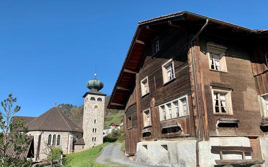 Blick auf das Walsermuseum und im Hintergrund der Zwiebelturm der Triesenberger Kirche.