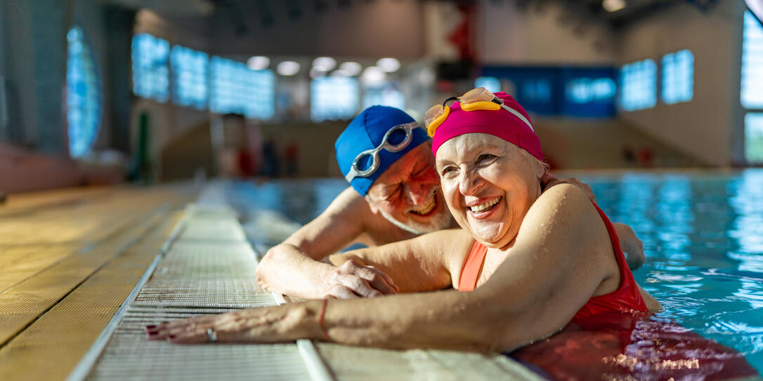 Two senior friends hanging out together in the swimming pool.