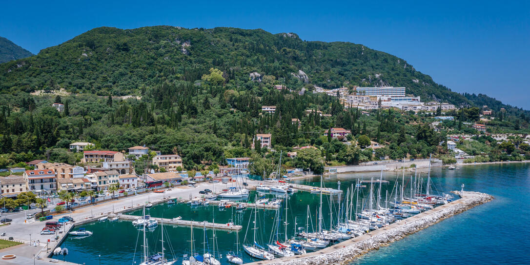 Sailing boats in Benitses village on the Ionian Sea shore, Corfu Island, Greece